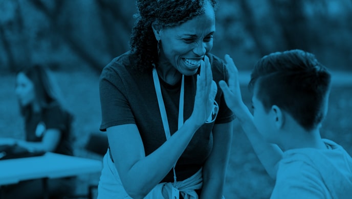 A woman high-fiving a boy