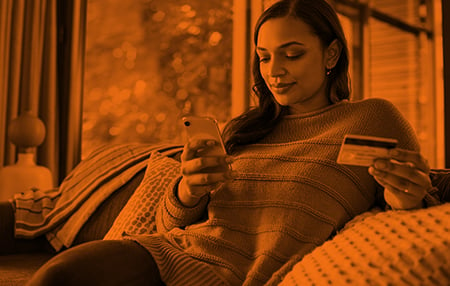 woman sitting on couch with phone in hand