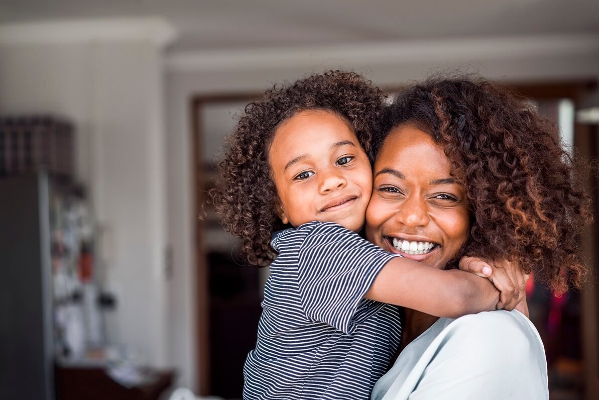 woman smiling while holding child