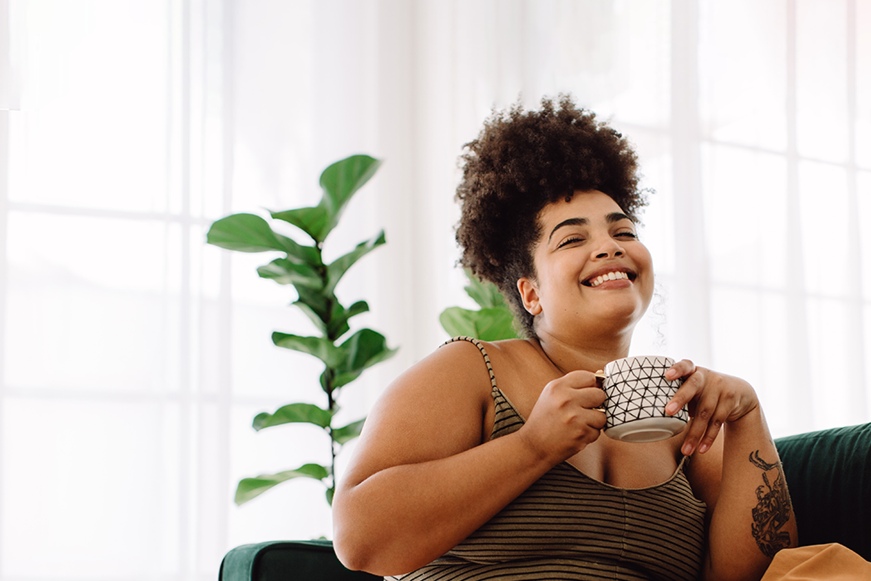 Woman Happy About Installment Loan Sitting & Drinking Coffee - Check 'n Go