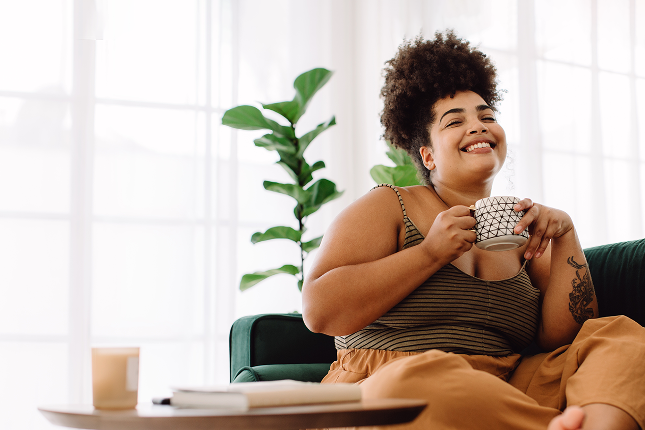 Woman Happy About Installment Loan Sitting & Drinking Coffee - Check 'n Go