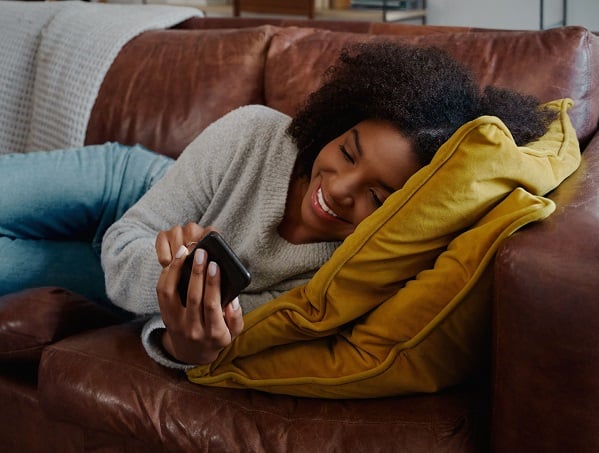 person on couch using phone