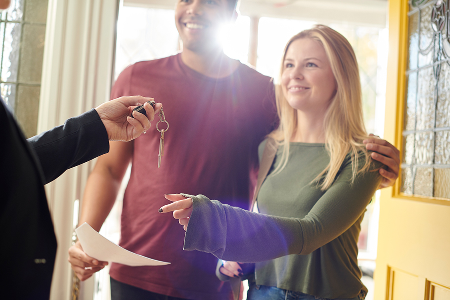 Man and woman receiving a key to a house.