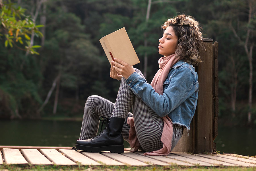 Woman Reading Finance Book on Dock - Check 'n Go