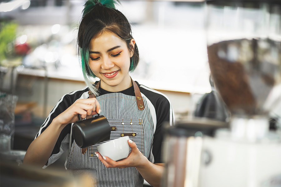 College Student Barista Smiling While Making Coffee