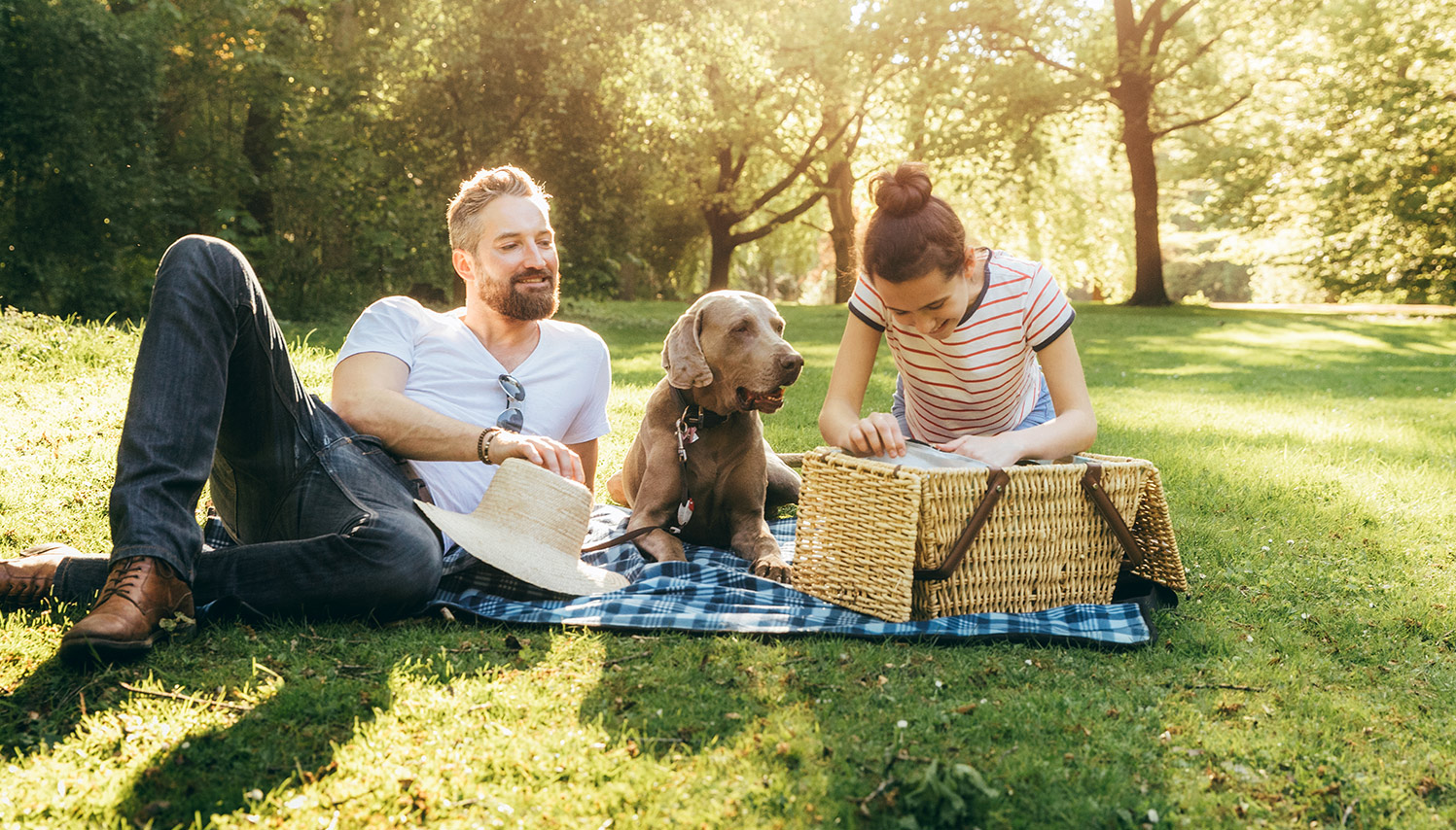 Father, Daughter, and Dog on a Picnic in a Park