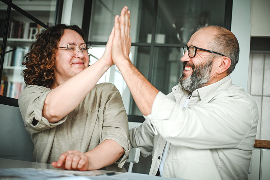 Man and Woman High Fiving Over Tax Return
