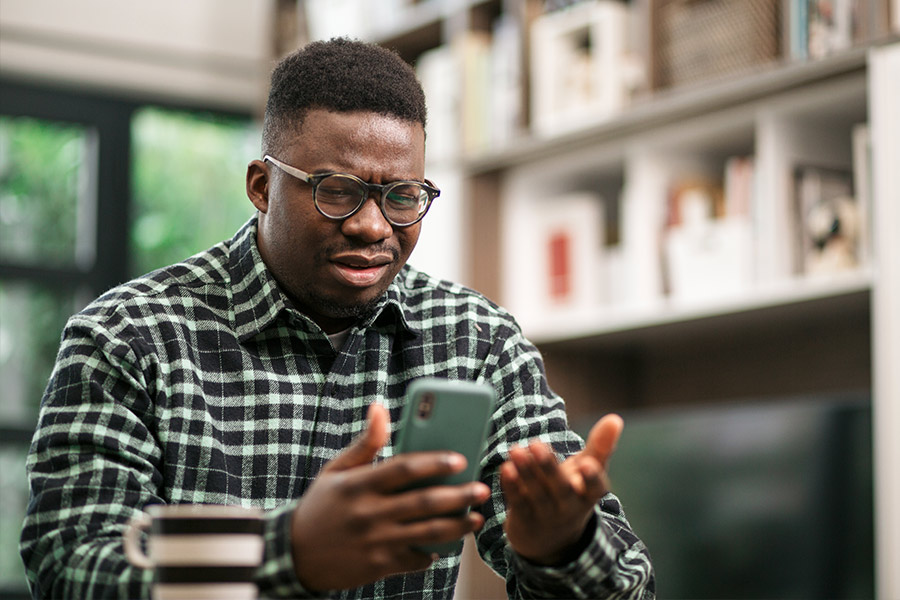 Man Dismayed While Looking at Overdraft Fee on His Phone