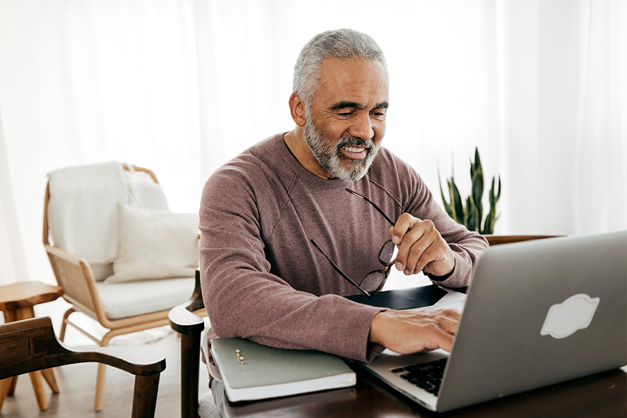 Man Viewing Tax Refund on Laptop - Check `n Go