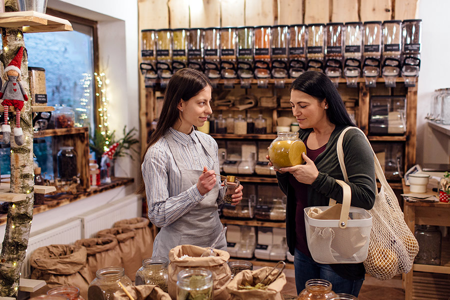 Two Women at Sustainable Grocery Store Smelling Spices