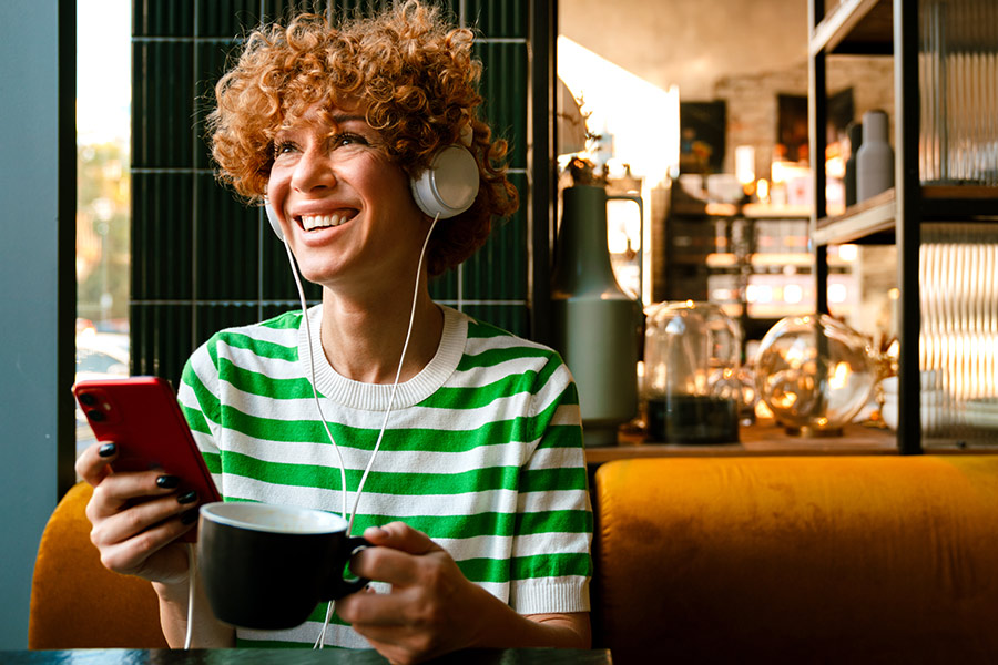 Woman Listening to a Podcast & Drinking Coffee - Check `n Go