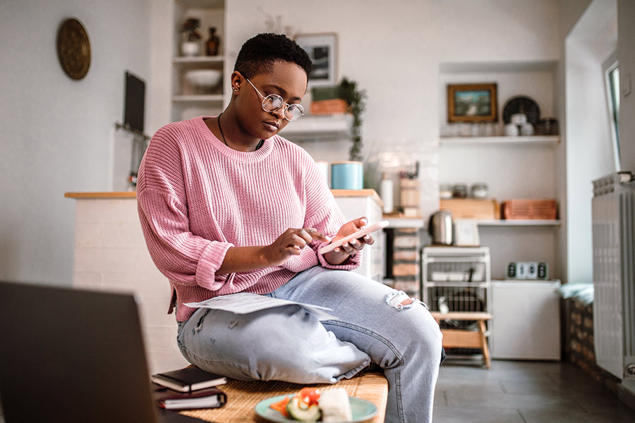 Woman Reviewing Unexpected Expenses on Mobile - Check `n Go