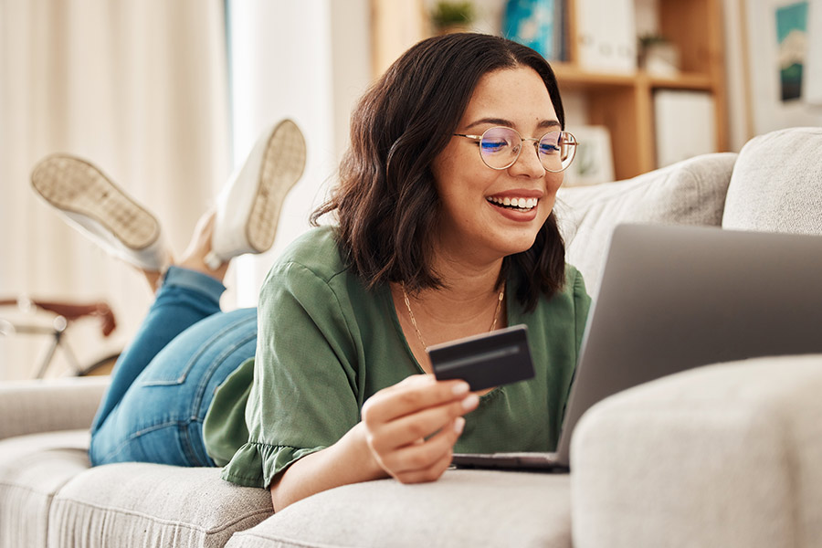 Woman with Netspend Card Laying on Couch with Laptop