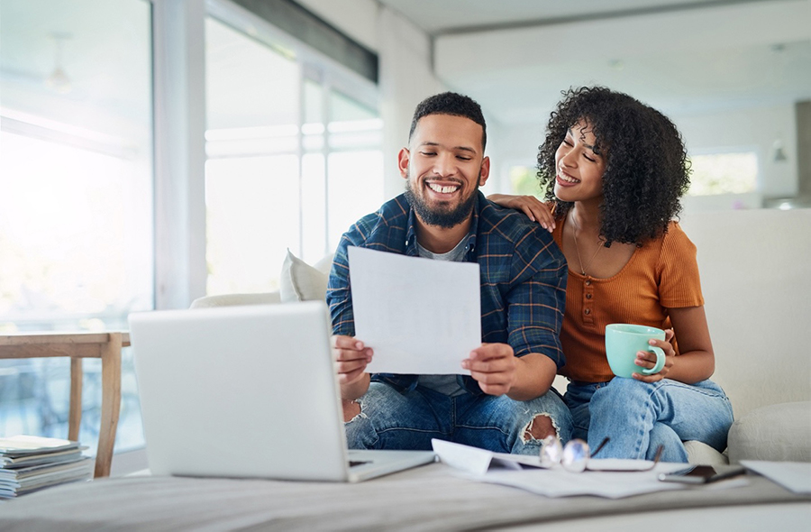 man and woman smiling looking at a document