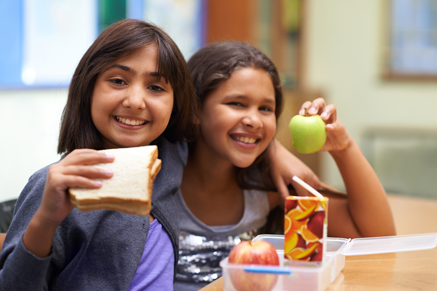 Two young girls eating lunch